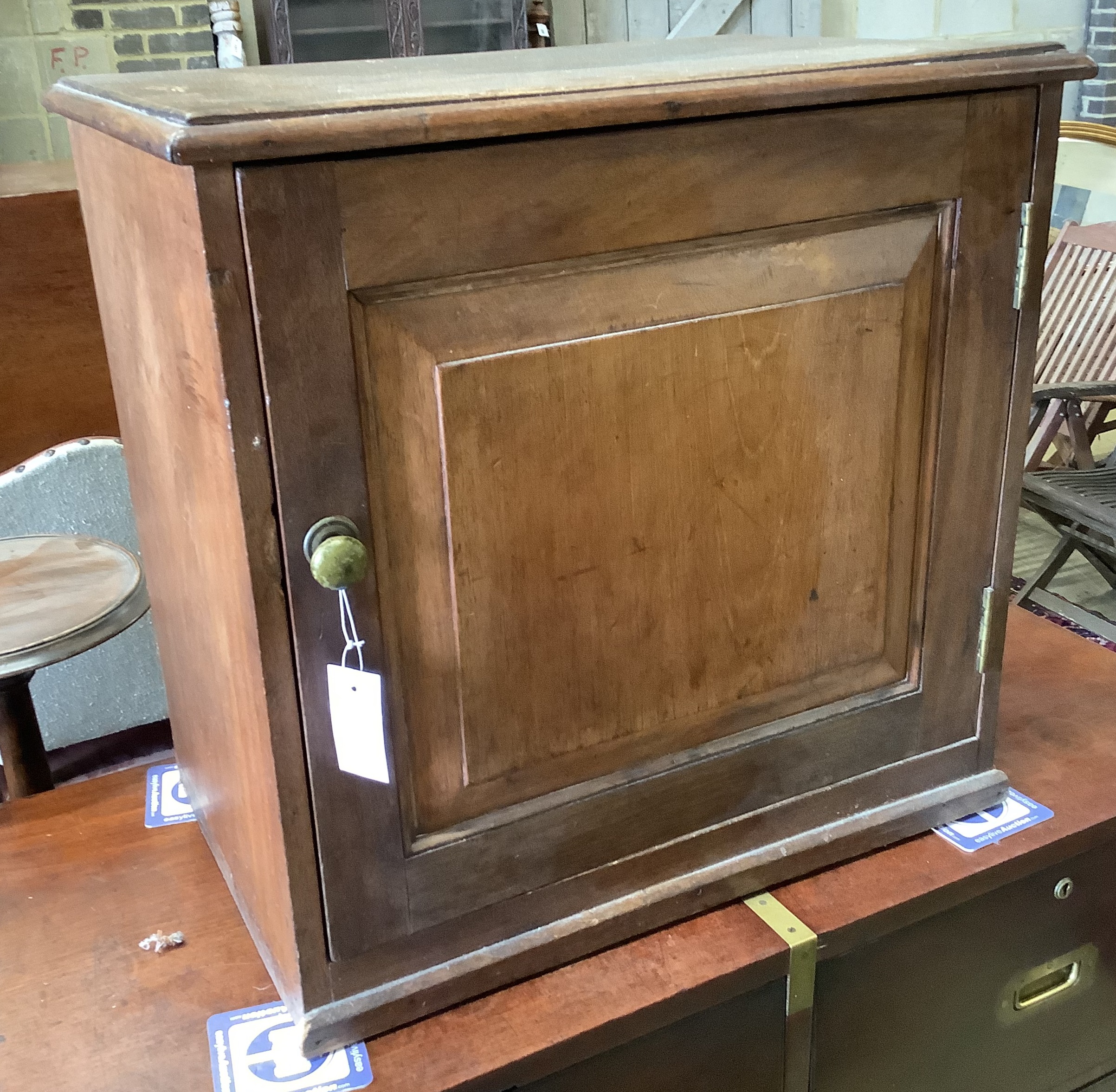 A Victorian mahogany cupboard, enclosed by a panelled door